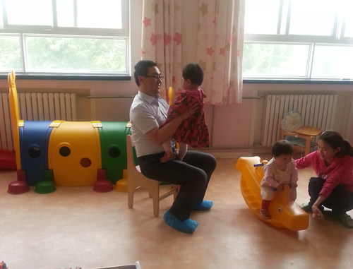 生命人寿汉中中心支公司总经理夏秋磊（左）与福利院的孩子游戏互动